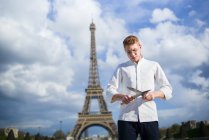 Cozinheiro de cabelo vermelho com facas em pé em frente à Torre Eiffel em Paris — Fotografia de Stock
