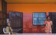КАМЕРУН - Африка - 5 апреля 2018 года: Улыбающиеся этнические женщины, стоящие и сидящие в доме — стоковое фото