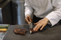 Koch schneidet gegrilltes Rindfleisch im Restaurant — Stockfoto