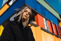 Приваблива блондинка дивиться на камеру проти барвистої будівлі — стокове фото