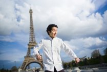 Chef japonês animado com facas em pé em frente à Torre Eiffel em Paris — Fotografia de Stock
