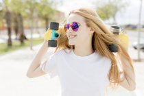 Blonde girl walking with penny board — Stock Photo