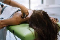 O fisioterapeuta que trata uma mulher usando equipamentos para radioterapia — Fotografia de Stock