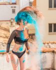 Magra donna sessuale in lingerie nera ricoperta di colorate polveri secche in piedi sul balcone — Foto stock