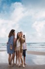 Woman and teenagers taking selfie on beach in summer — Stock Photo