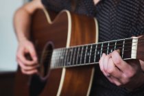 Close-up of human hands playing acoustic guitar — Stock Photo