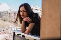Ritratto di giovane donna bruna sognante in piedi sul balcone — Foto stock
