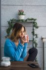 Chilling jovem mulher tomando café na varanda — Fotografia de Stock