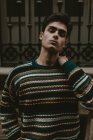 Junger selbstbewusster Teenager im Pullover, der mit geschlossenen Augen auf der Straße steht — Stockfoto