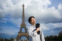 Nachdenklicher japanischer Koch steht mit Schürze vor dem Eiffelturm in Paris — Stockfoto