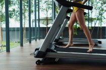 Female legs running on race track in gym — Stock Photo