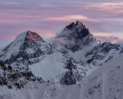 Schneebedeckte Berge unter dramatischem Himmel bei Sonnenuntergang — Stockfoto