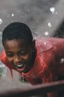 Kamerun - Afrika - 5. April 2018: Mädchen steht unter Wassertropfen — Stockfoto