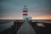 View to lighthouse tower at the seaside in the evening lights. — Stock Photo