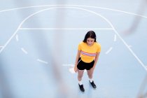 Молода жінка стоїть на спортивному майданчику — стокове фото
