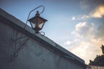 Старый винтажный фонарь на здании на закате — стоковое фото
