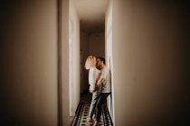 Glückliches Paar umarmt und küsst sich im Saal zu Hause — Stockfoto