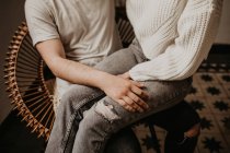 Couple sitting in armchair and embracing at home — Stock Photo