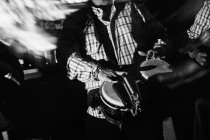 Musicisti che suonano chitarre e tamburi nel night club, ripresa in bianco e nero con lunga esposizione — Foto stock