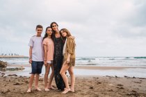 Портрет женщины и подростков, стоящих на пляже — стоковое фото