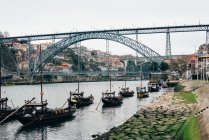 Ряд различных лодок на берегу в канале старого города, Порту, Португалия — стоковое фото