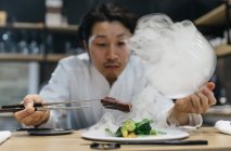 Шеф-кухар готує в ресторані з чашкою диму — стокове фото