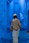 Женщина идет по голубой окрашенной улице в Марокко — стоковое фото