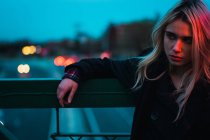 Thoughtful blonde woman looking away in dusk — Stock Photo