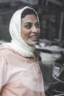 Lächelnde Marokkanerin mit Hijab sitzt hinter Fensterscheibe — Stockfoto