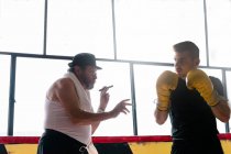 Vista lateral do homem adulto com boxer de treinamento de charuto no ginásio. — Fotografia de Stock