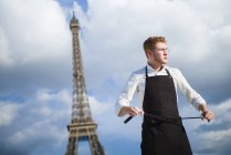 Rothaarige Köchin in Uniform vor dem Eiffelturm in Paris — Stockfoto