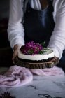 Woman holding cake decorated with flowers — Stock Photo