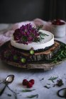 Yummy cake decorated with fresh flowers on wooden platter — Stock Photo