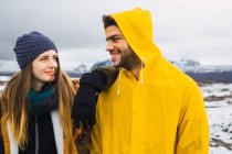 Мужчина и женщина стоят вместе и улыбаются на фоне холодных гор Исландии. — стоковое фото