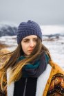 Frau in warmer Kleidung steht in kalter Natur und schaut weg — Stockfoto