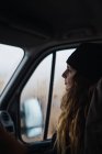 Woman in hat sitting inside of car on passengers seat — Stock Photo