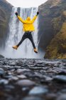 Чоловік стрибає біля водоспаду — стокове фото