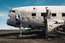 Hombre sentado en un viejo avión destruido - foto de stock