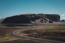 Paesaggio montano e strada riccia sotto il cielo blu, Islanda — Foto stock