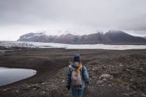 Mujer con mochila de pie y disfrutando de las montañas nevadas vista - foto de stock