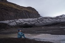 Женщина сидит перед скалами и наслаждается видом — стоковое фото