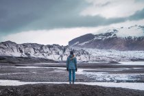 Woman standing in snowy mountains in winter and enjoying view — Stock Photo
