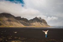 Mujer de pie en las montañas frías y disfrutando de la vista, Islandia - foto de stock