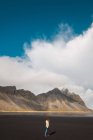Mujer de pie en las montañas frías y disfrutando de la vista, Islandia - foto de stock