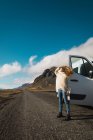 Mulher de pé perto de ônibus viajando em montanhas, Islândia — Fotografia de Stock