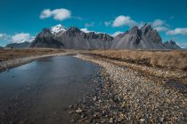 Freddo torrente di cristallo e montagne rocciose sullo sfondo, Islanda — Foto stock