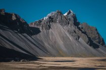 Vale da montanha e penhascos rochosos sob o céu azul na Islândia — Fotografia de Stock