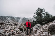 Backpacker standing in mountains — Stock Photo