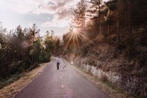 Man with dog walking on road — Stock Photo