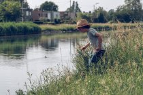 Niño de pie en el río - foto de stock
